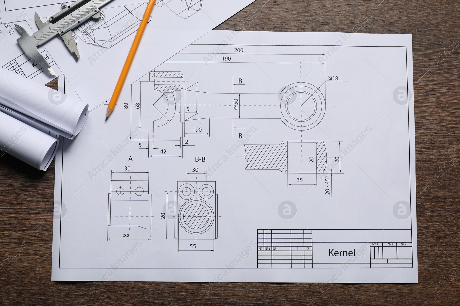 Photo of Different engineering drawings, vernier caliper and pencil on wooden table, top view