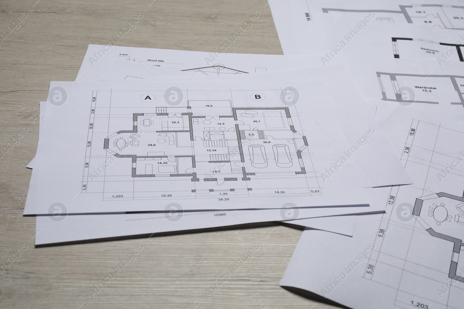 Photo of Different architectural drawings on wooden table, closeup