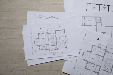 Different architectural drawings on wooden table, top view