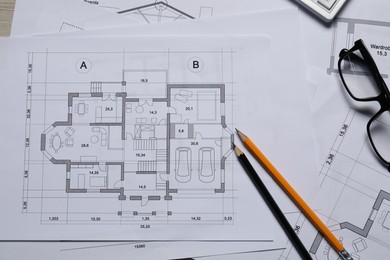 Different architectural drawings, glasses and pencils, top view