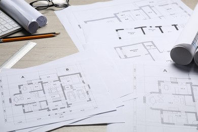 Photo of Different architectural drawings and tools on wooden table, closeup