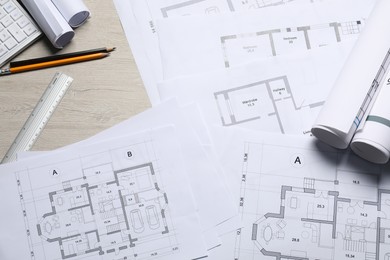 Photo of Different architectural drawings and tools on wooden table, flat lay