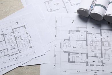 Photo of Different architectural drawings on wooden table, above view