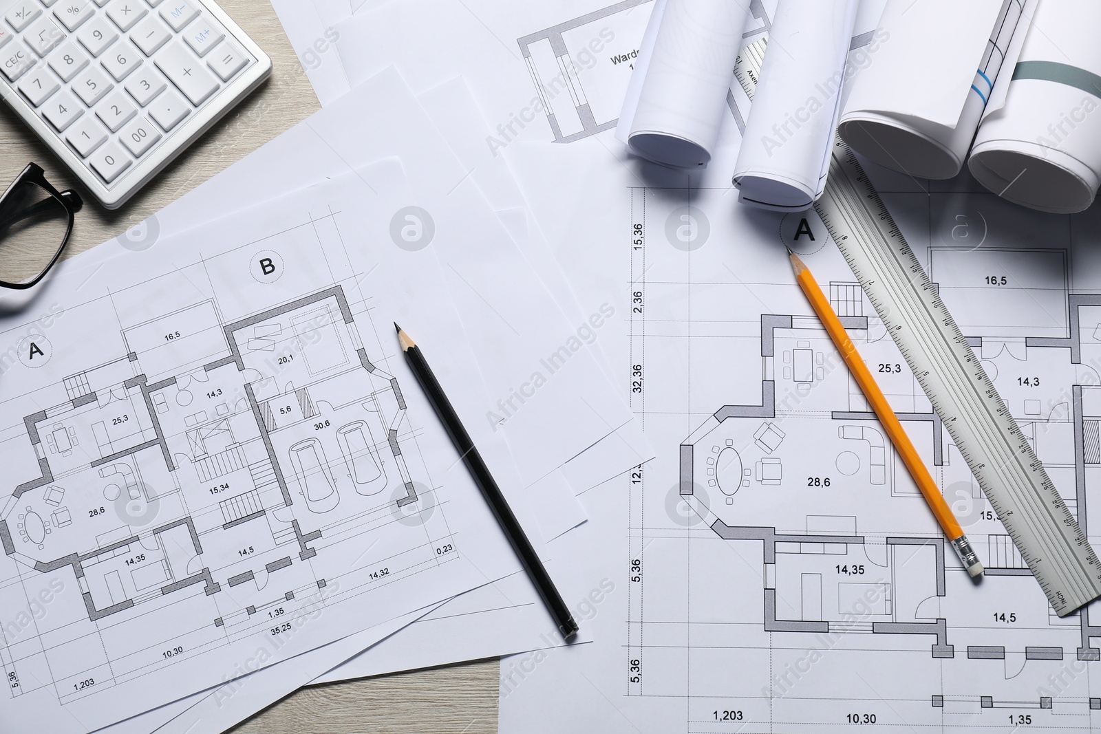 Photo of Different architectural drawings and tools on wooden table, flat lay