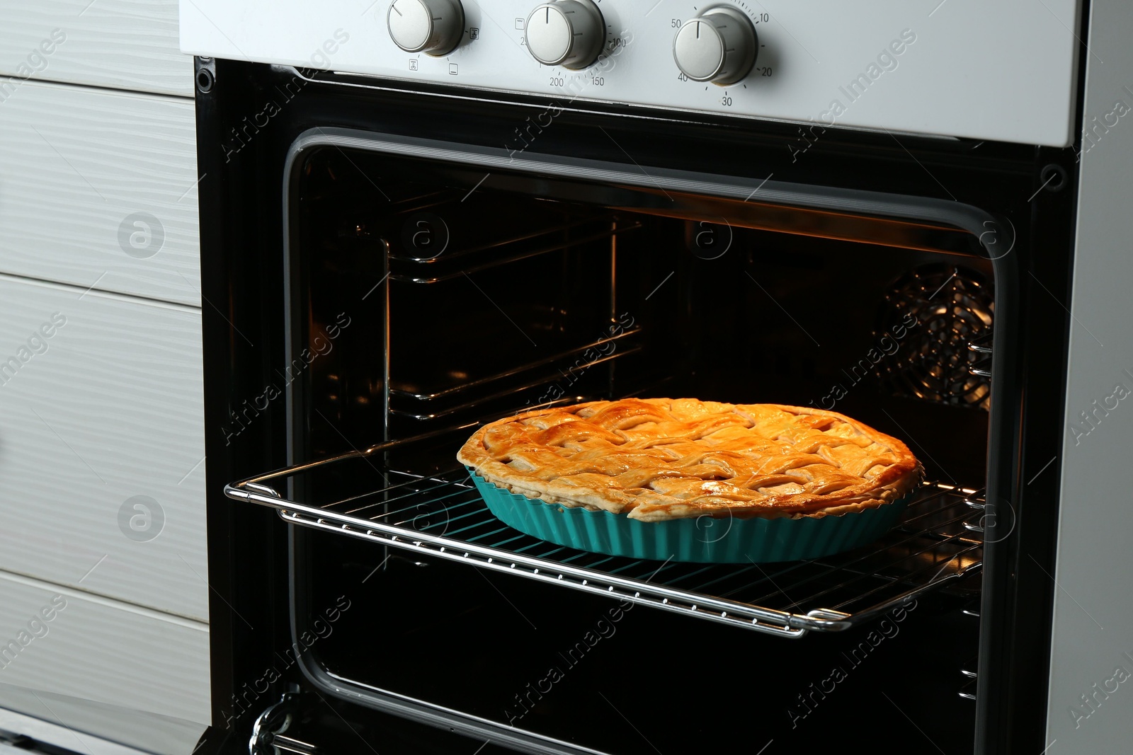 Photo of Baking dish with homemade apple pie in oven