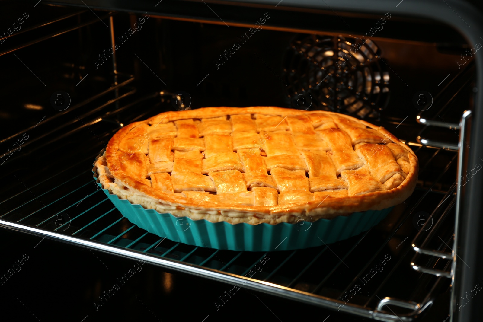 Photo of Baking dish with homemade apple pie in oven, closeup