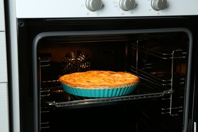 Photo of Baking dish with homemade apple pie in oven