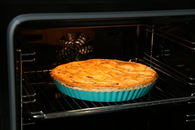 Photo of Baking dish with homemade apple pie in oven