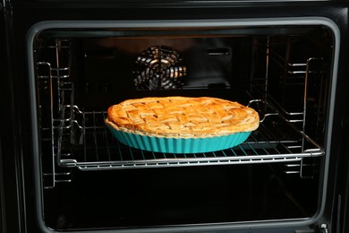 Photo of Baking dish with homemade apple pie in oven