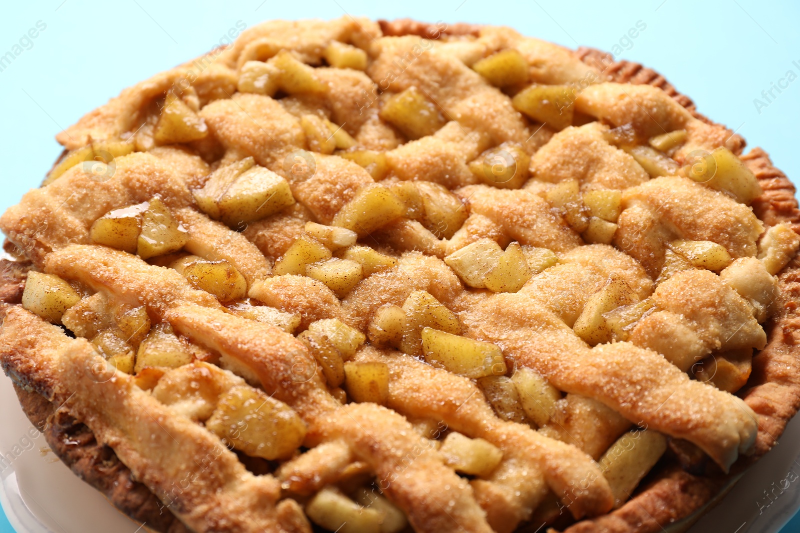 Photo of Tasty homemade apple pie on light blue background, closeup