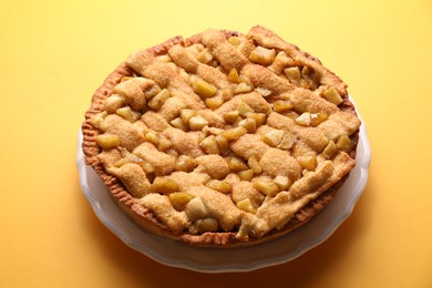 Tasty homemade apple pie on yellow background