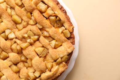 Photo of Tasty homemade apple pie on beige background, top view. Space for text