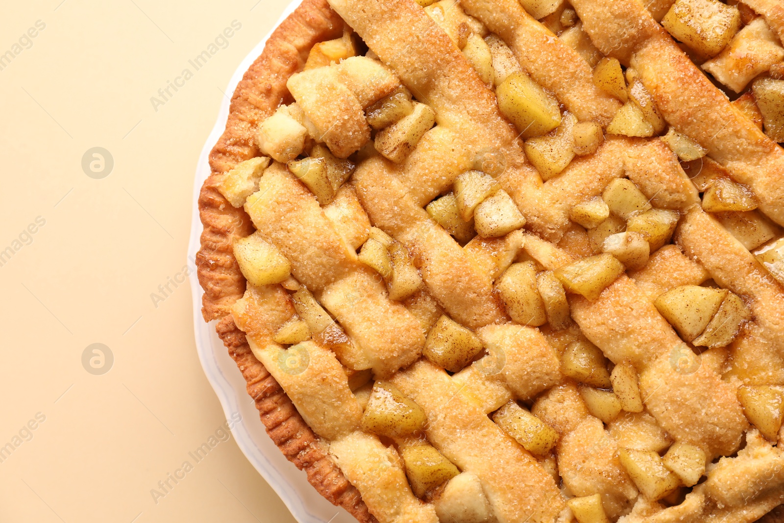 Photo of Tasty homemade apple pie on beige background, top view. Space for text