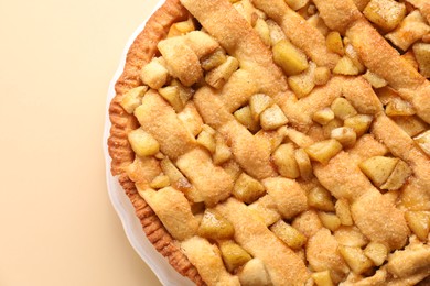 Photo of Tasty homemade apple pie on beige background, top view. Space for text