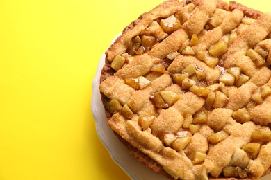 Tasty homemade apple pie on yellow background, above view. Space for text