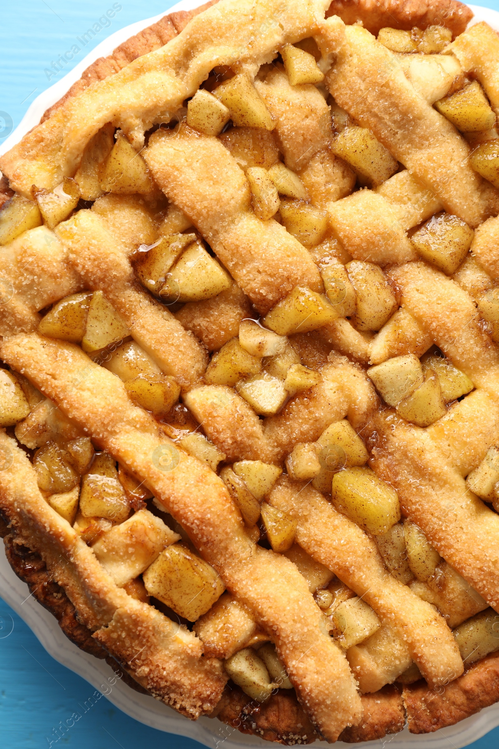 Photo of Tasty homemade apple pie on light blue table, top view