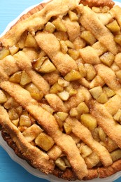 Tasty homemade apple pie on light blue table, top view