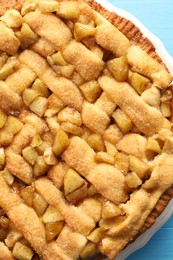 Photo of Tasty homemade apple pie on light blue table, top view