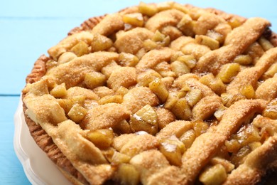 Tasty homemade apple pie on light blue table, closeup