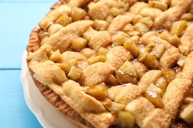 Photo of Tasty homemade apple pie on light blue table, closeup