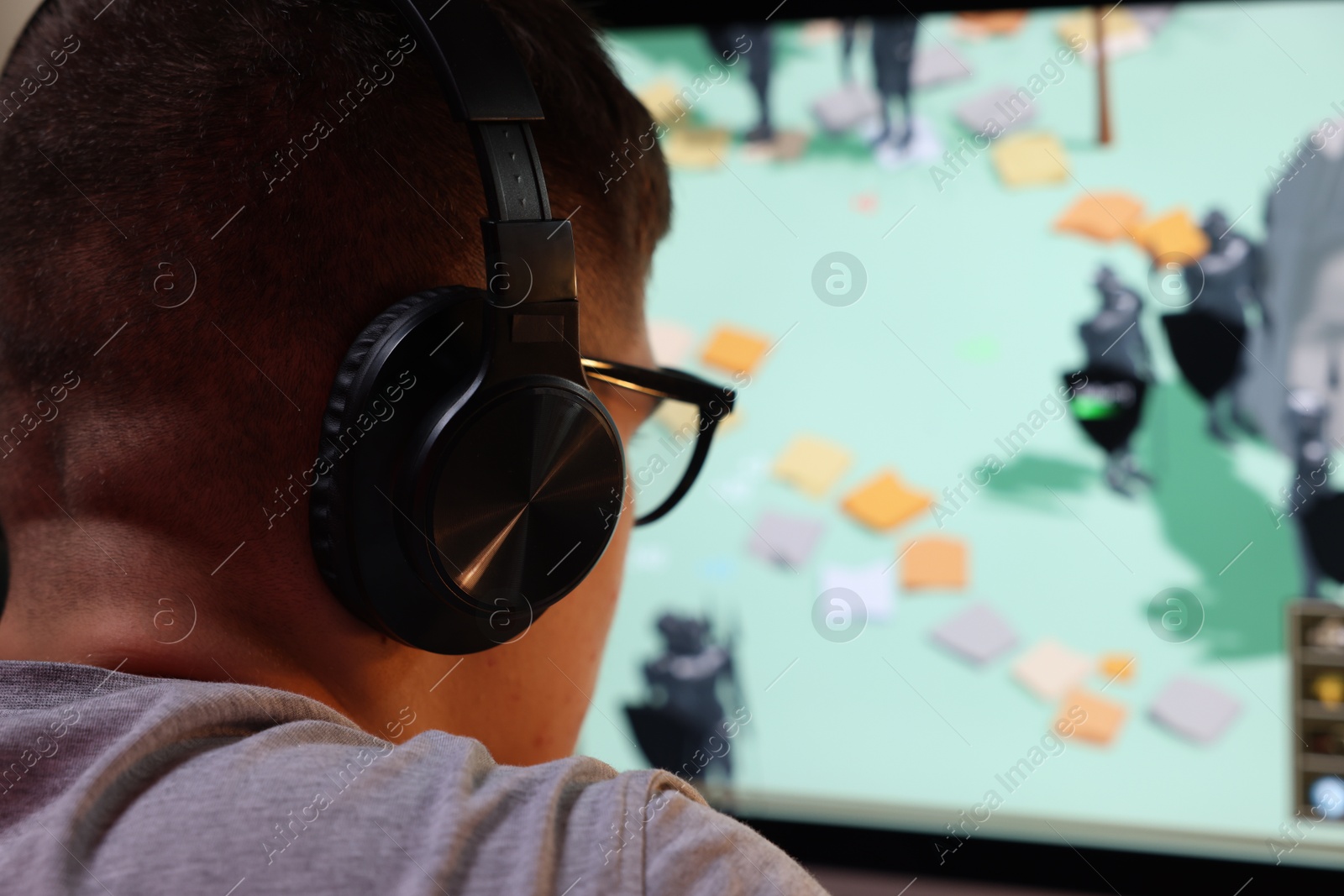 Photo of Young man playing video game at table indoors, closeup