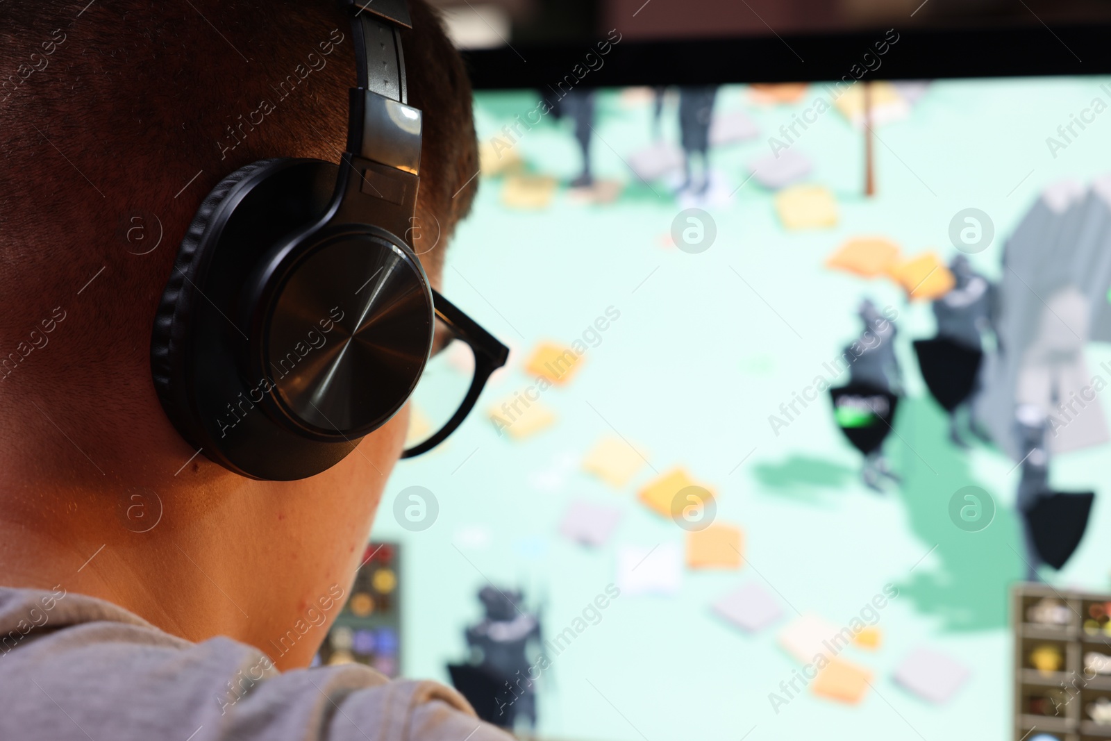 Photo of Young man playing video game at table indoors, closeup