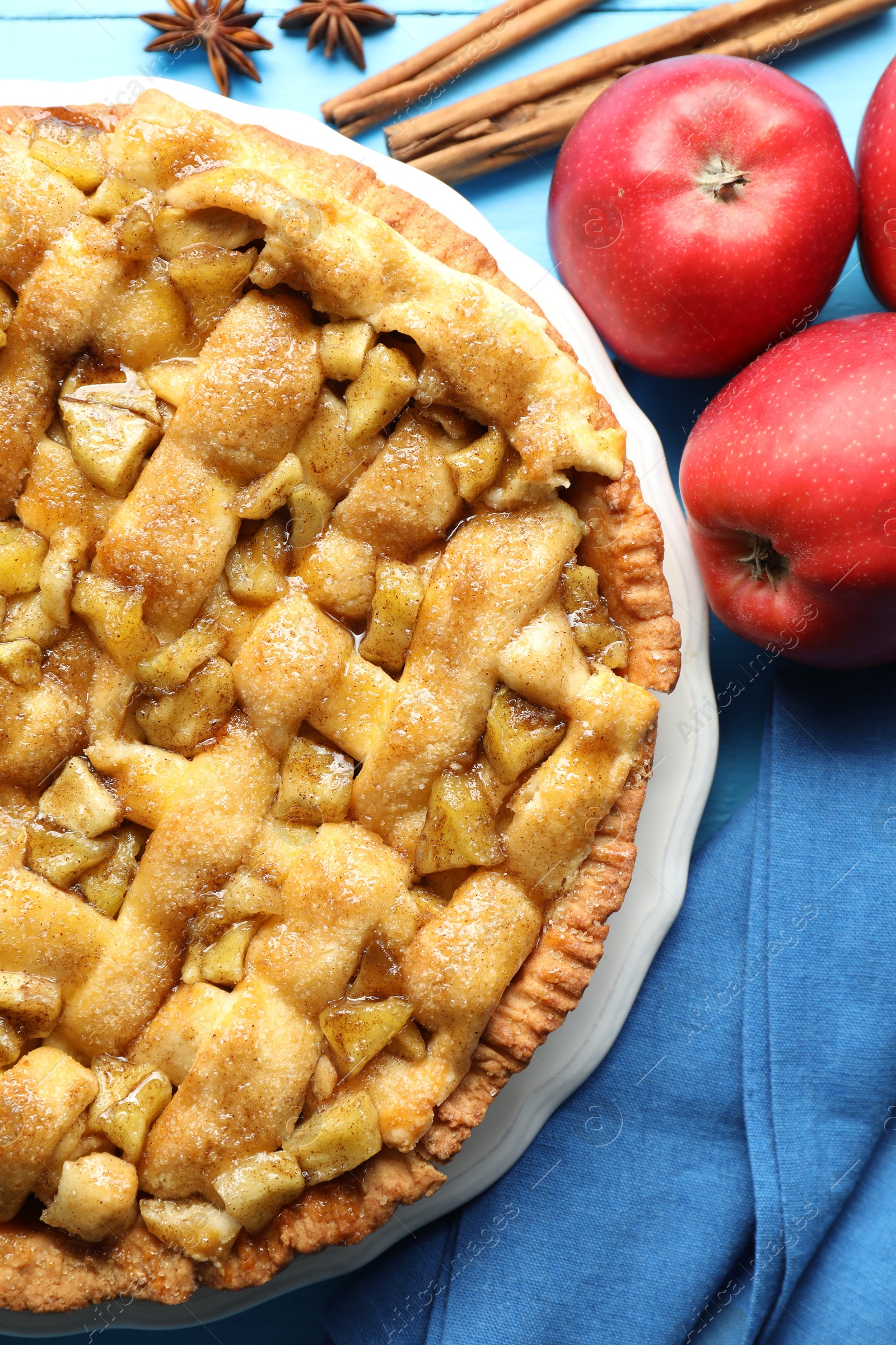 Photo of Homemade apple pie and ingredients on light blue wooden table, flat lay