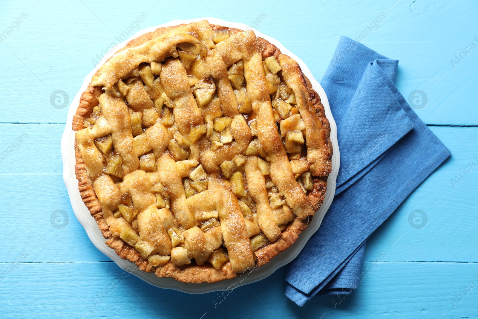 Photo of Homemade apple pie on light blue wooden table, top view