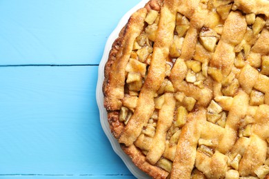 Photo of Homemade apple pie on light blue wooden table, top view. Space for text