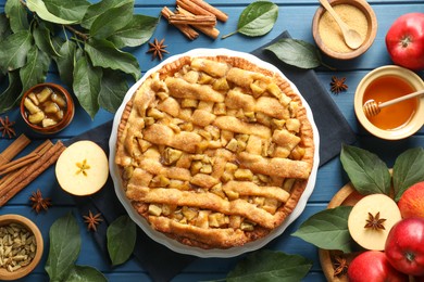 Photo of Homemade apple pie and ingredients on blue wooden table, flat lay