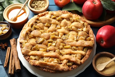 Homemade apple pie and ingredients on blue wooden table