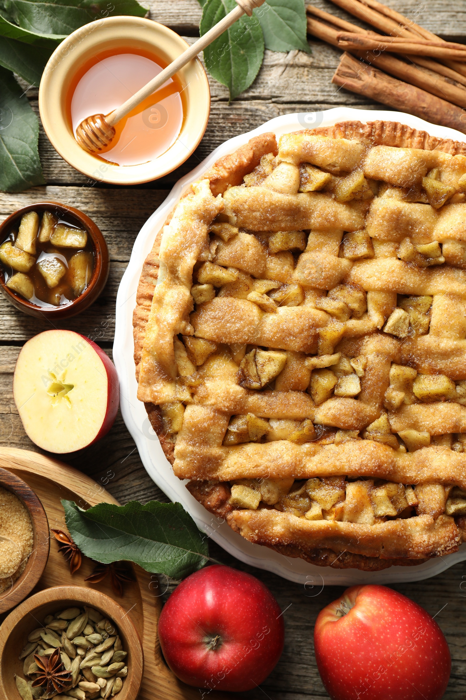 Photo of Homemade apple pie and ingredients on wooden table, flat lay