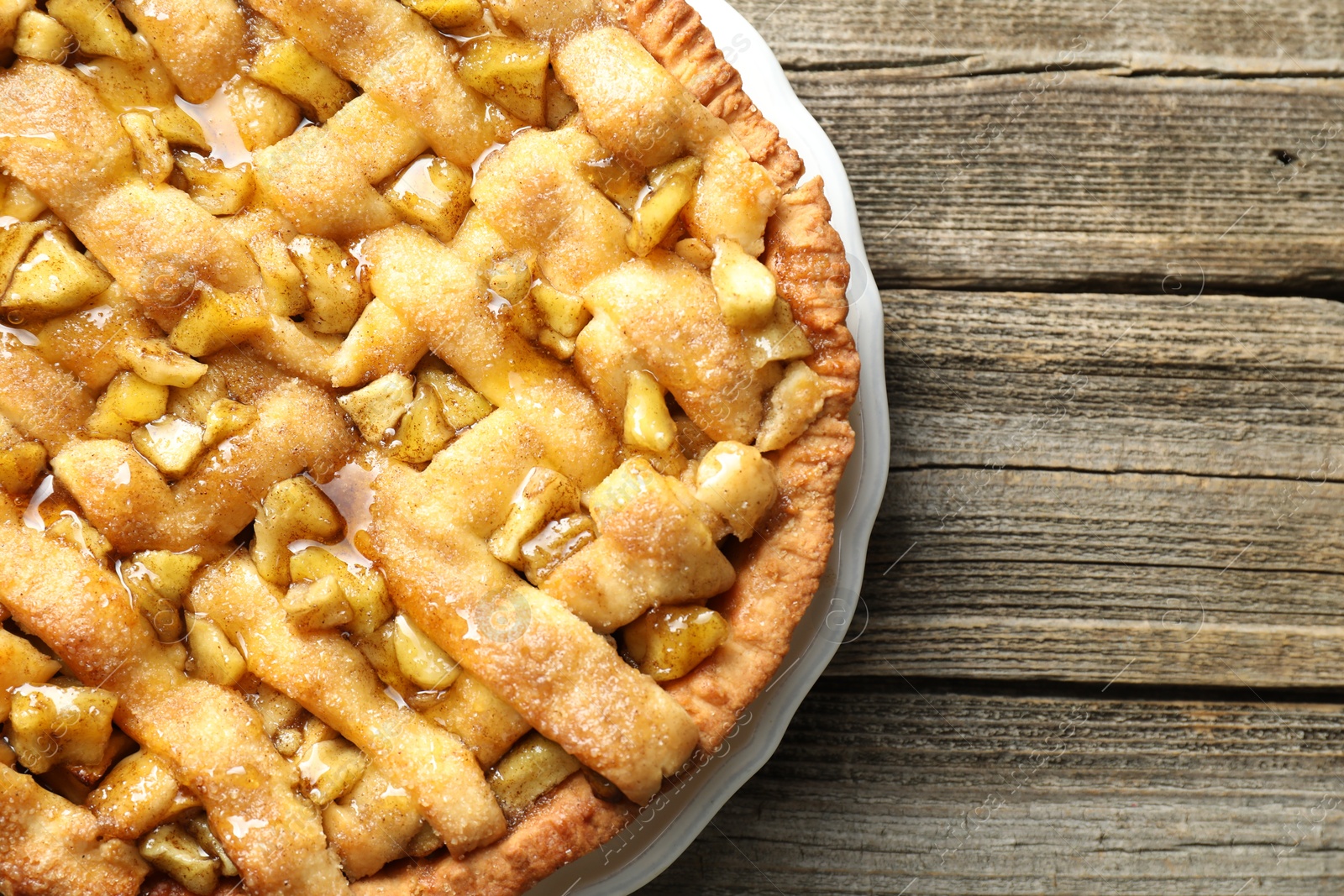 Photo of Homemade apple pie on wooden table, top view. Space for text