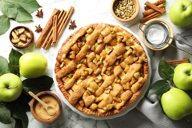 Photo of Homemade apple pie and ingredients on white marble table, flat lay