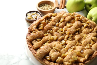 Homemade apple pie and ingredients on white marble table, closeup