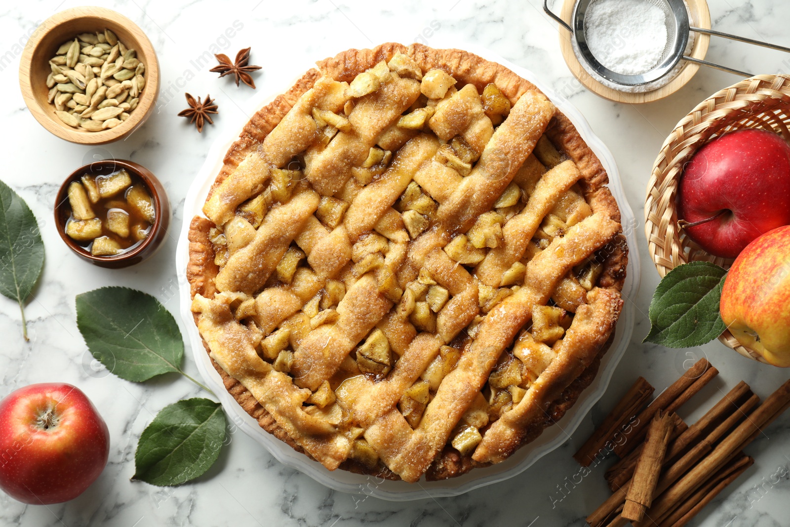 Photo of Homemade apple pie and ingredients on white marble table, flat lay