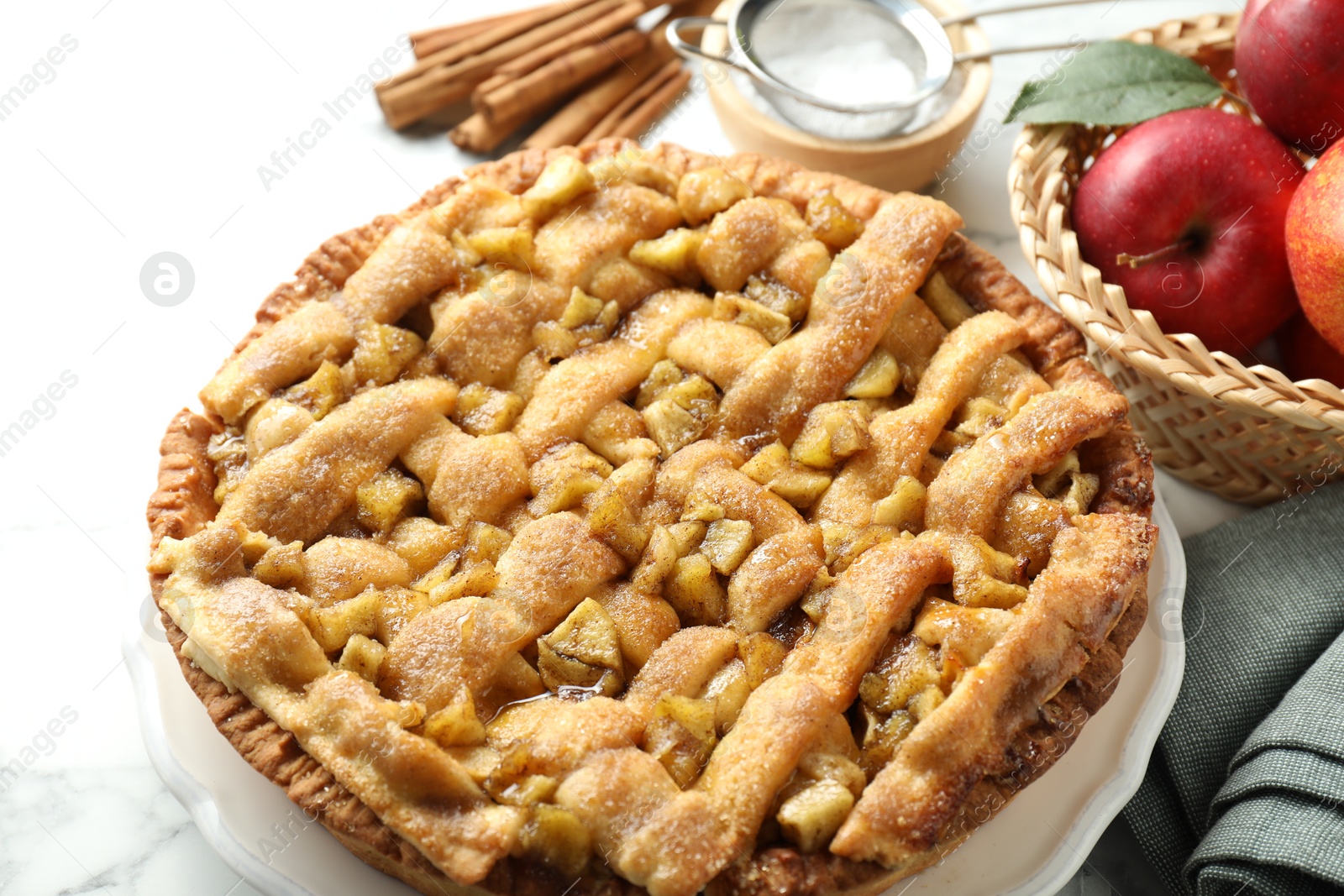 Photo of Homemade apple pie and ingredients on white marble table