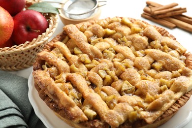 Homemade apple pie and ingredients on white marble table, closeup