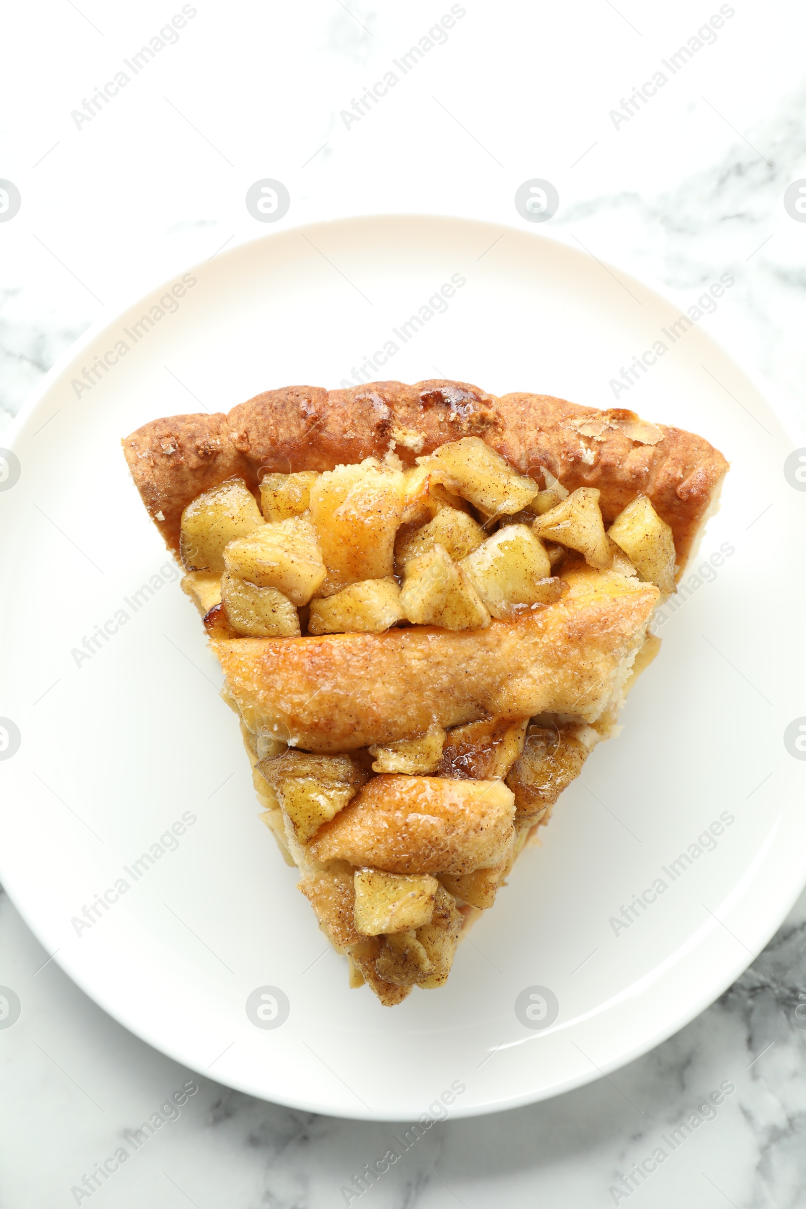 Photo of Slice of homemade apple pie on white marble table, top view