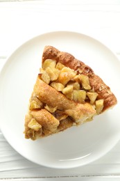 Photo of Slice of homemade apple pie on white wooden table, top view