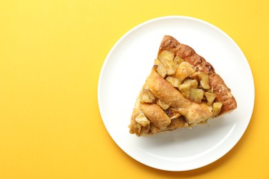 Photo of Slice of homemade apple pie on orange background, top view. Space for text