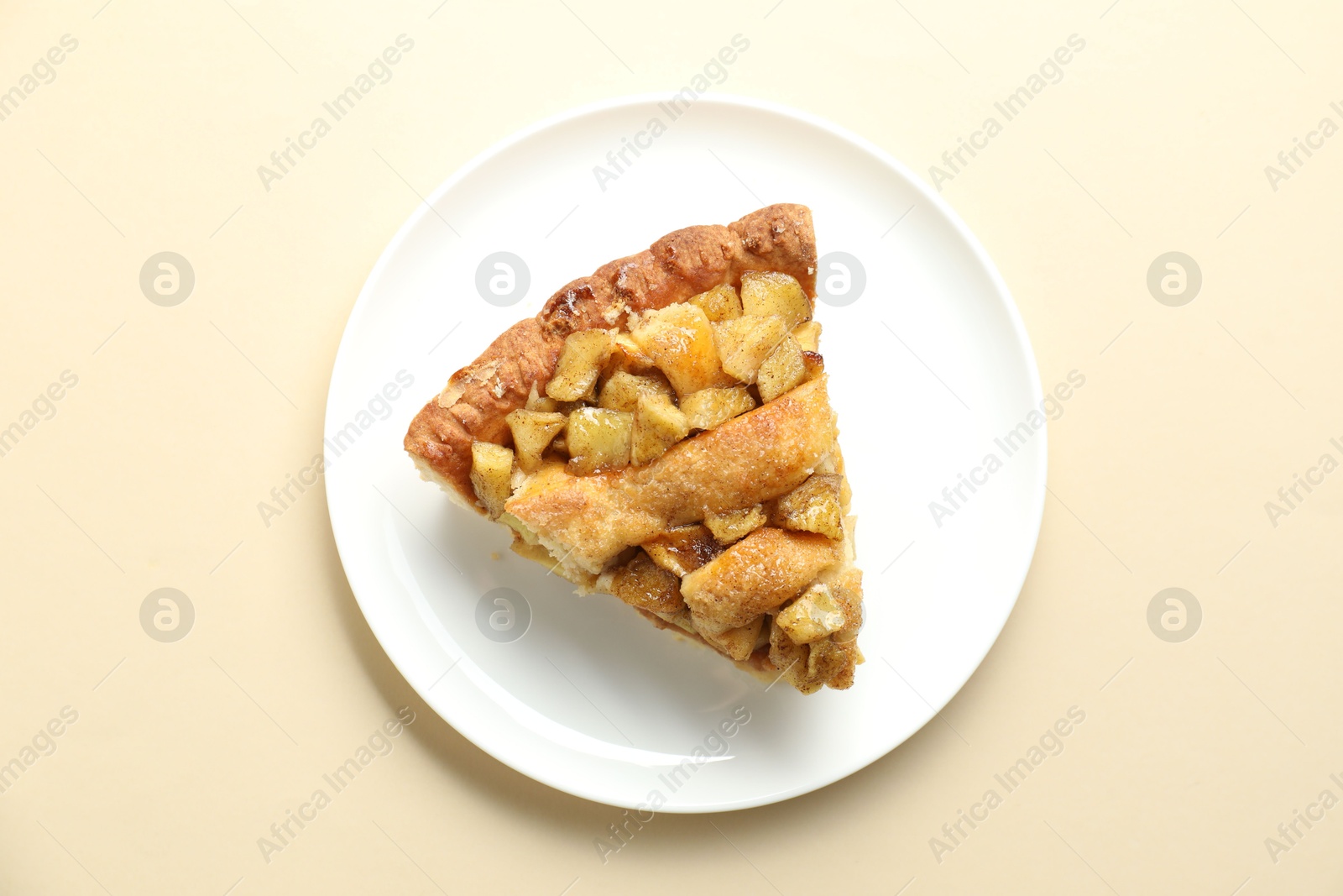 Photo of Slice of homemade apple pie on beige background, top view