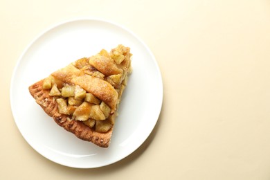 Photo of Slice of homemade apple pie on beige background, top view. Space for text