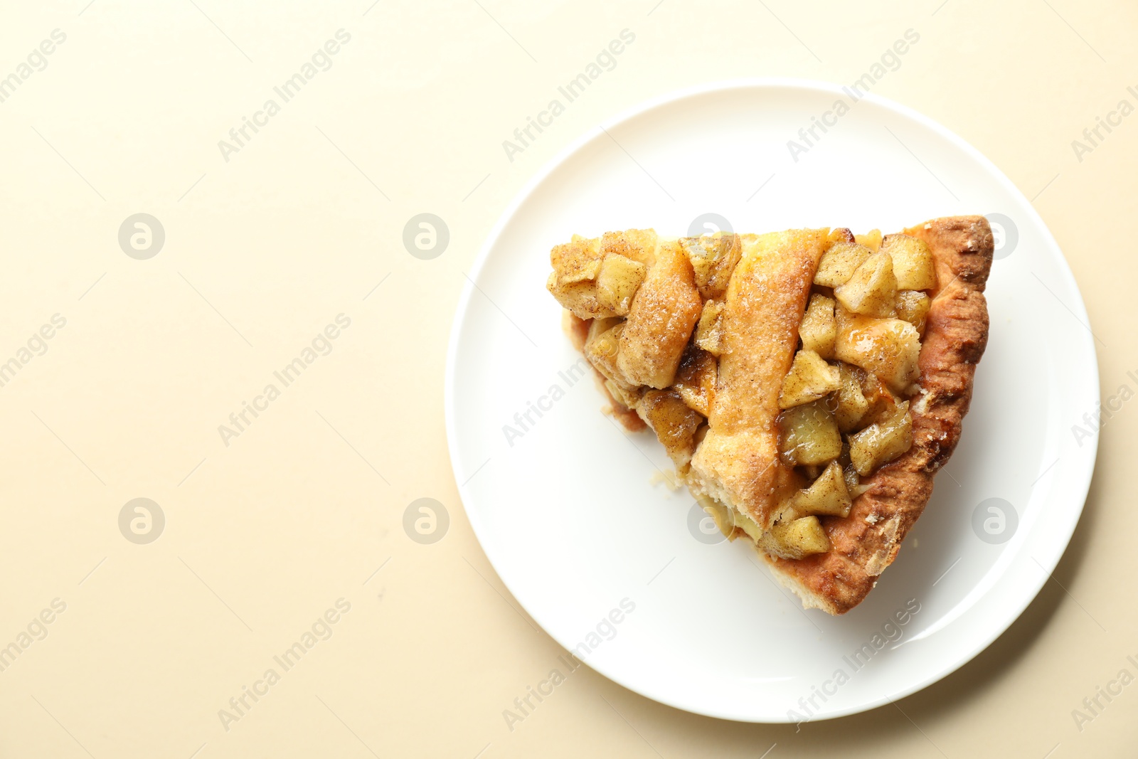 Photo of Slice of homemade apple pie on beige background, top view. Space for text