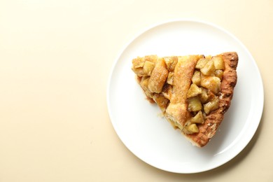 Photo of Slice of homemade apple pie on beige background, top view. Space for text