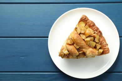 Photo of Slice of homemade apple pie on blue wooden table, top view. Space for text