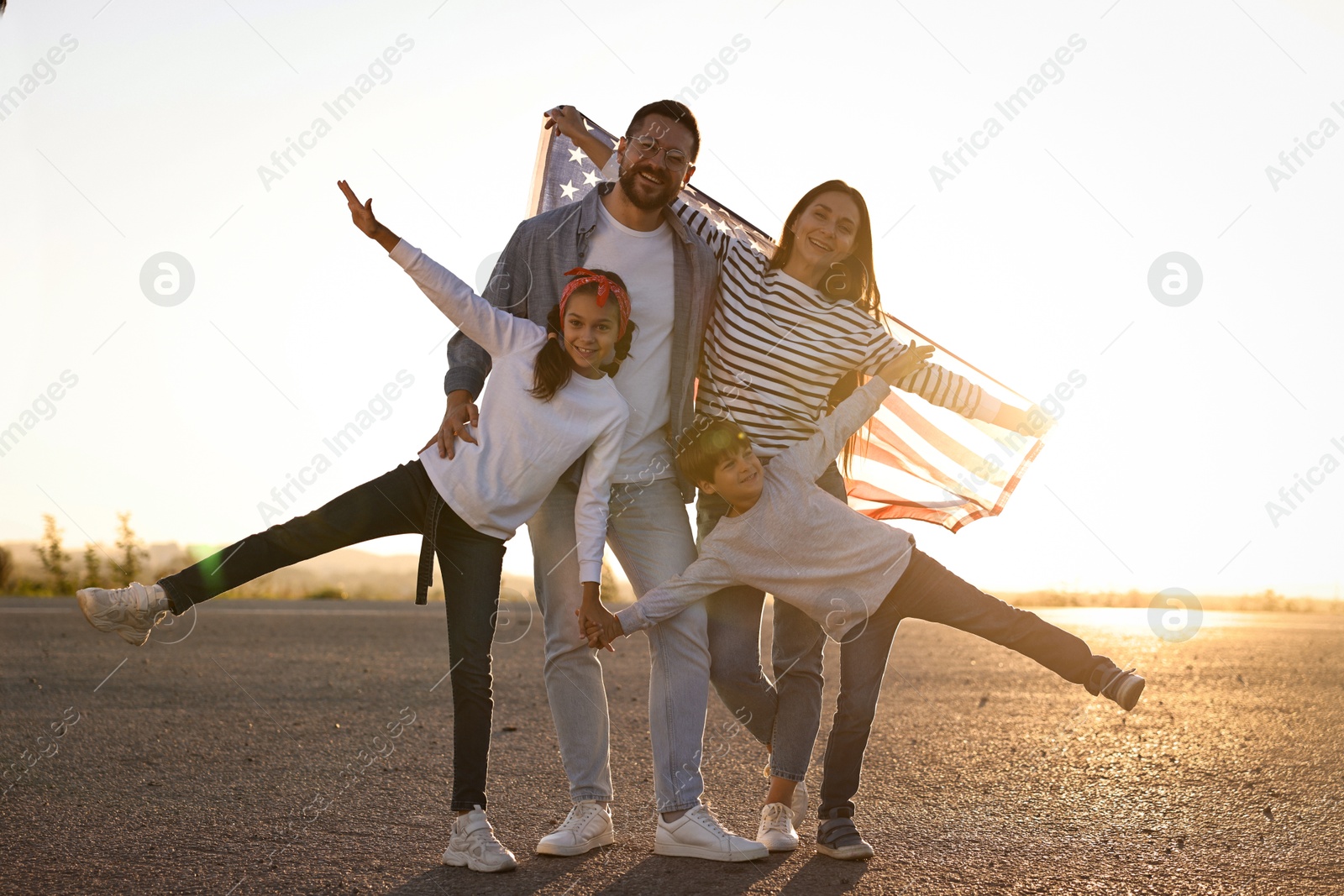 Photo of Happy family with flag of USA outdoors