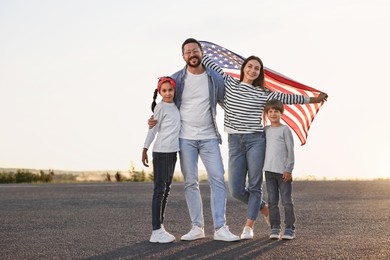 Photo of Happy family with flag of USA outdoors. Space for text