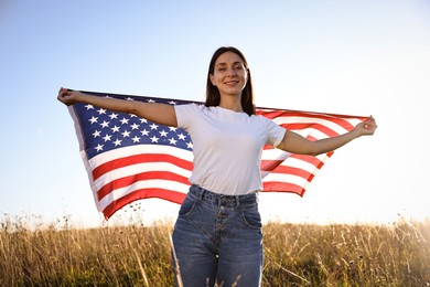 Photo of Happy woman with flag of USA outdoors