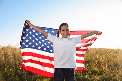 Happy girl with flag of USA outdoors